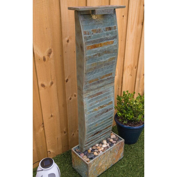 Natural Stone Floor Fountain with Light Rectangular Base Supports The water Wall, with River Stones Resting on The Bottom